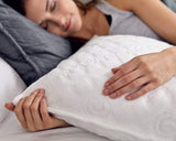 Woman sleeping in bed while holding a Gravity Pillow.