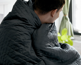 Man with Grey Blanket wrapped around his shoulders.